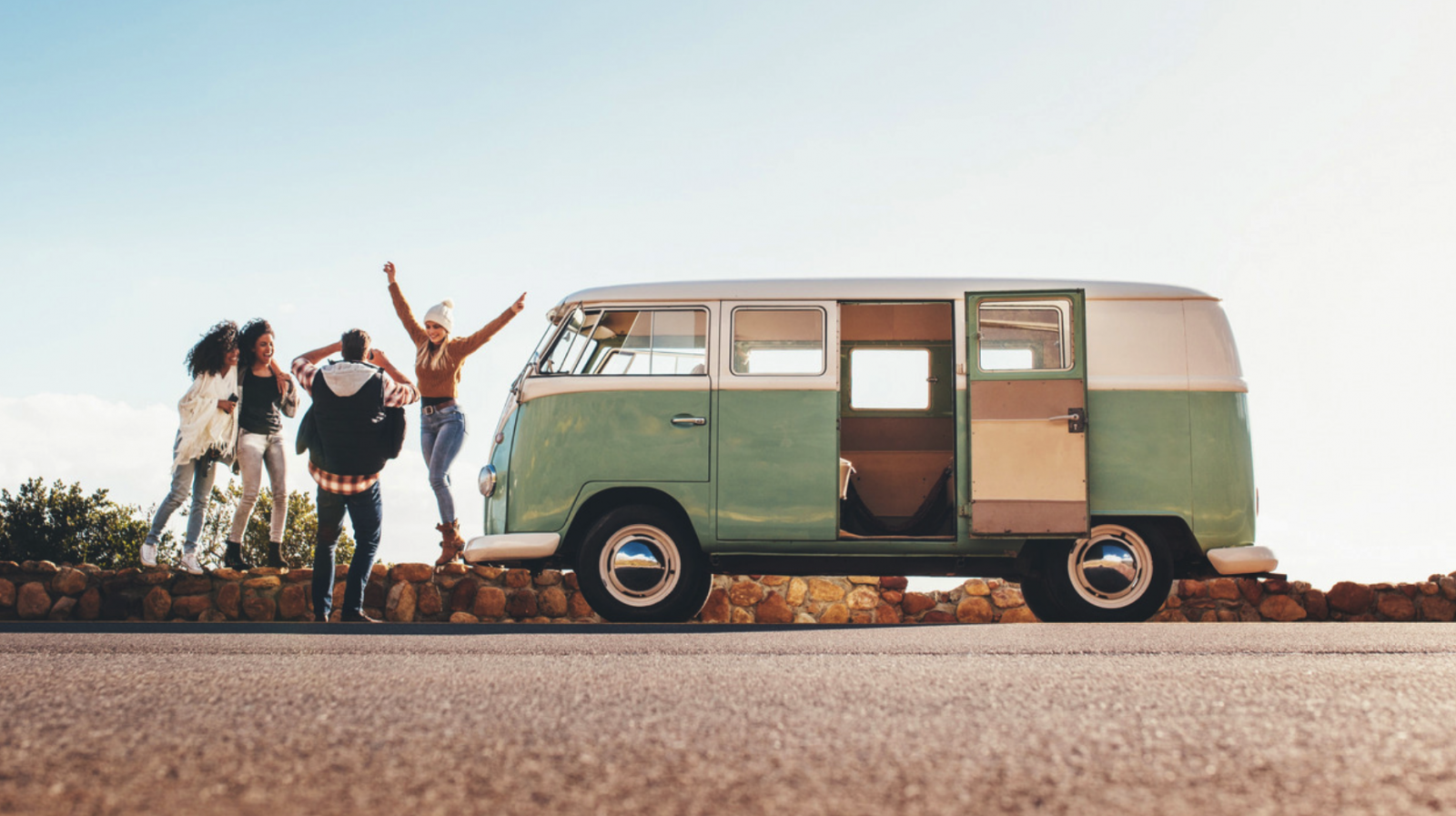 group of friends stopped on side of road with minivan