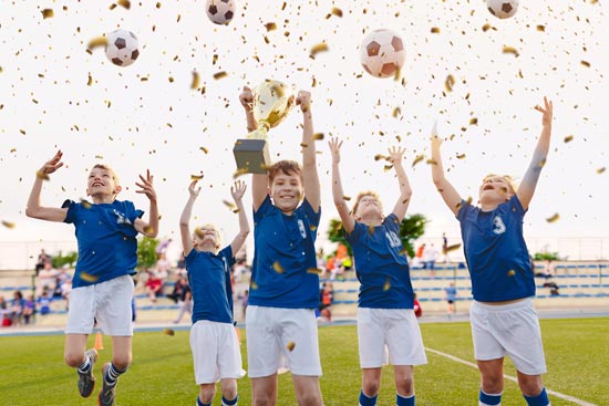 Boys soccer team holding trophy, celebrating