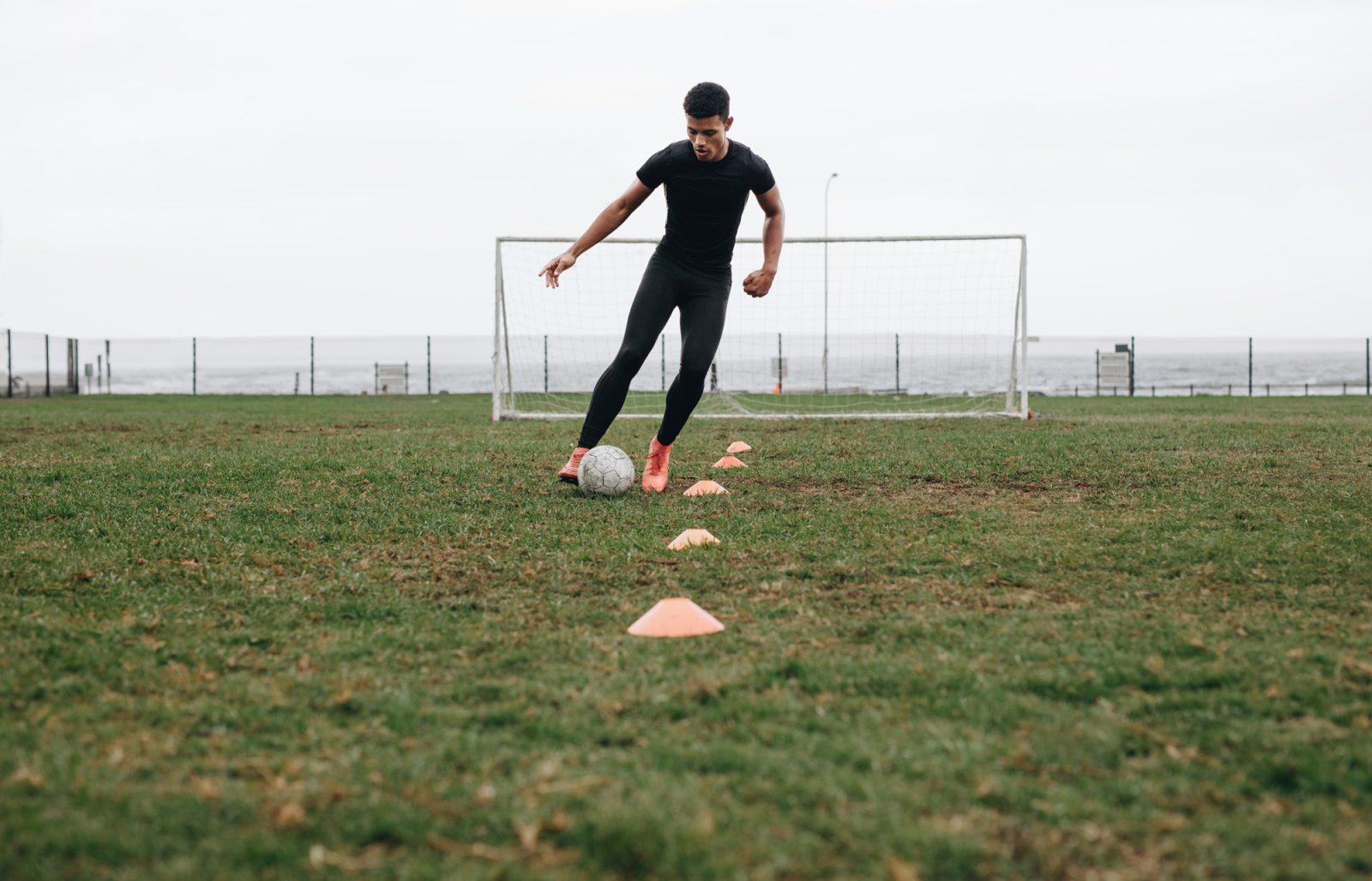 soccer player dribbling cones