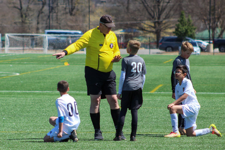 Soccer referee talking to youth player