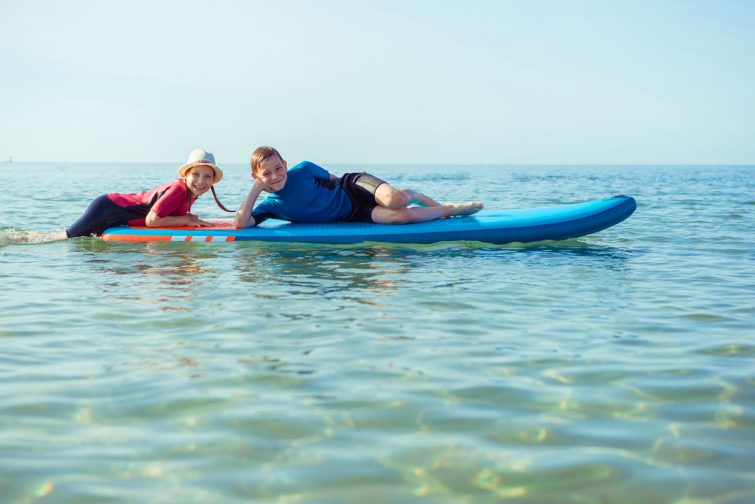 kids playing on paddleboard in the ocean